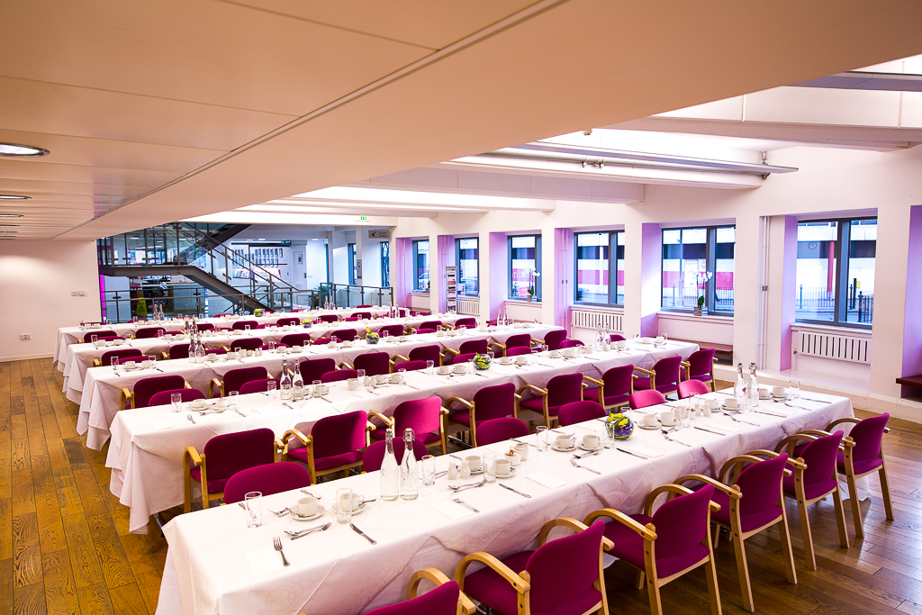 Café in Churchill House: elegant dining setup with pink chairs for events and meetings.