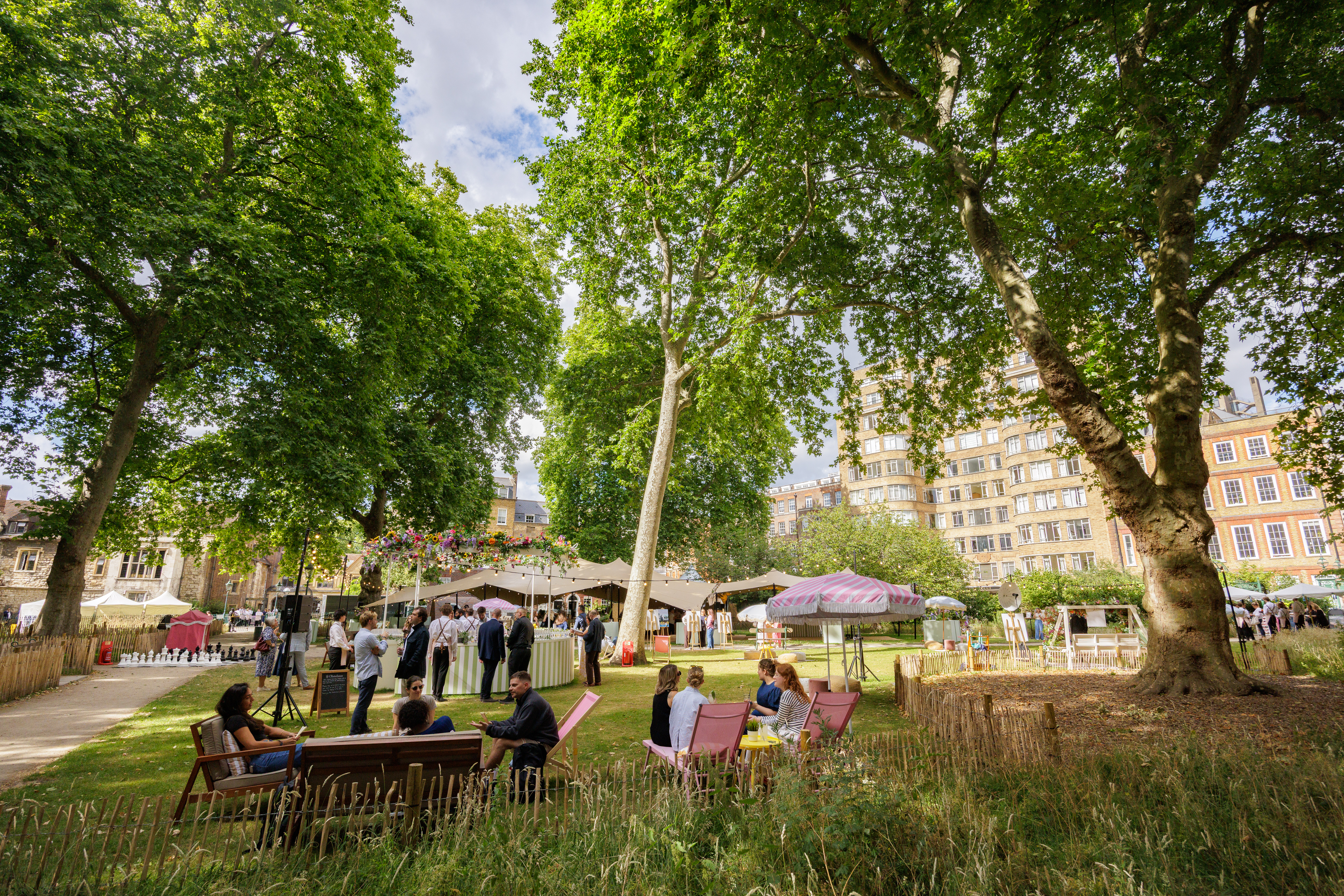 Outdoor summer party venue at Charterhouse Square with lush greenery and shaded seating.