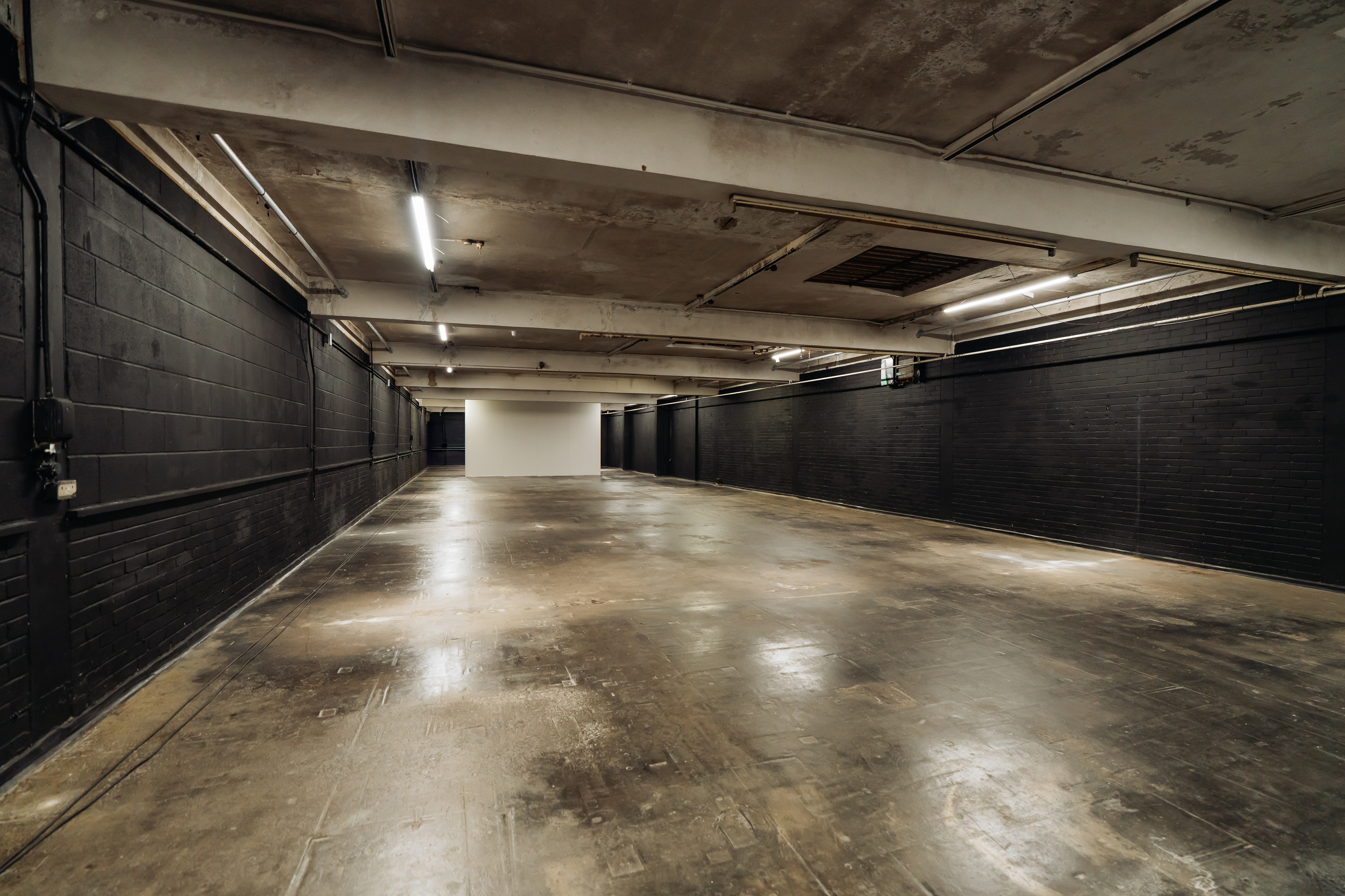 Spacious industrial event venue with concrete floor, ideal for corporate gatherings and exhibitions.