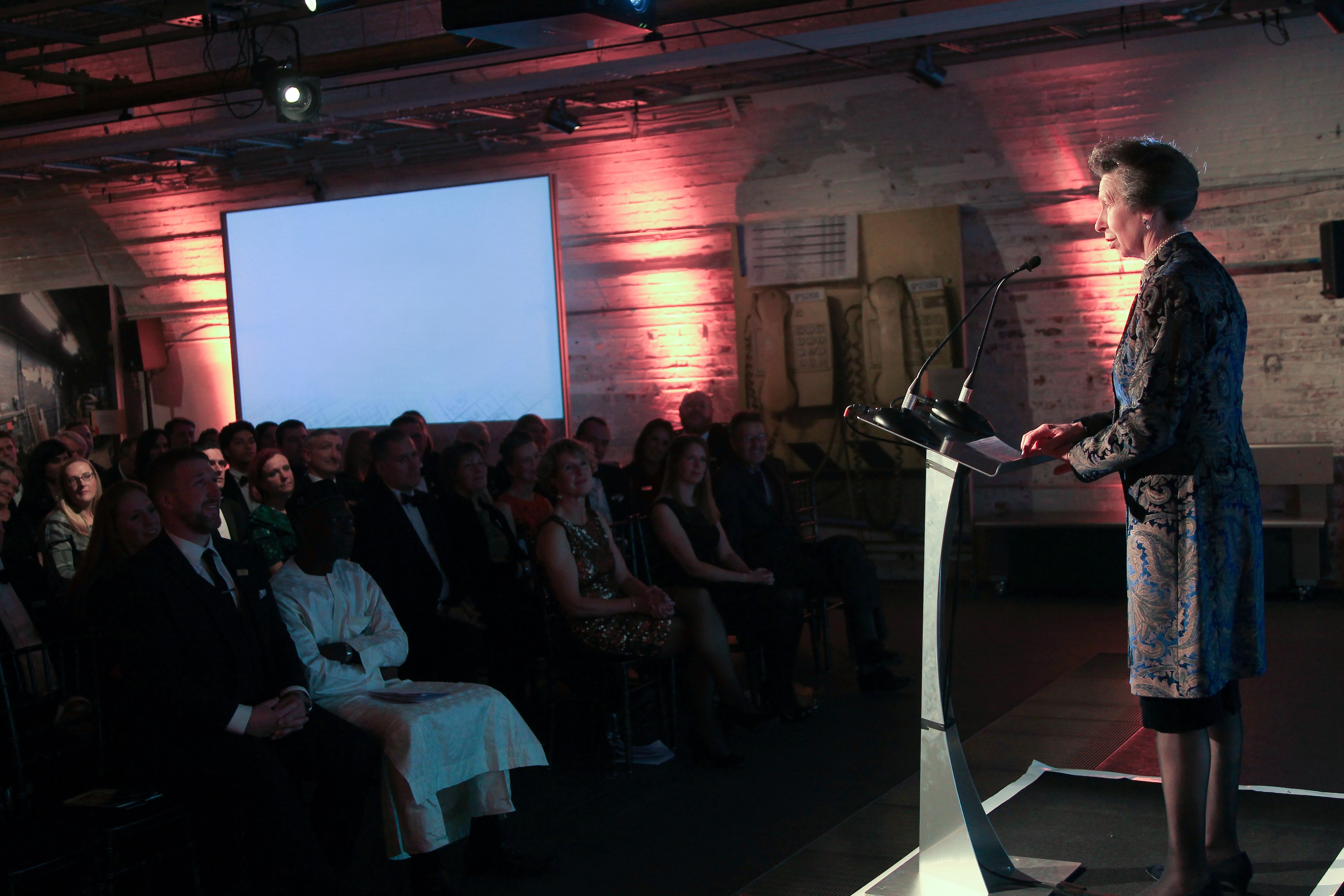 Speaker at podium in The Postal Museum during a formal conference event.