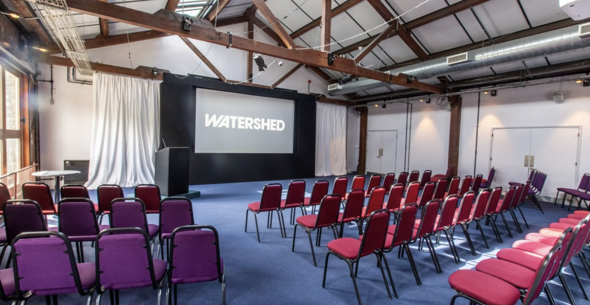 Waterside 3 event space with large screen, ideal for meetings and presentations.