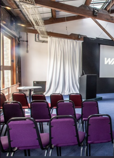 Waterside 3 event space with sleek podium, ideal for conferences and workshops.