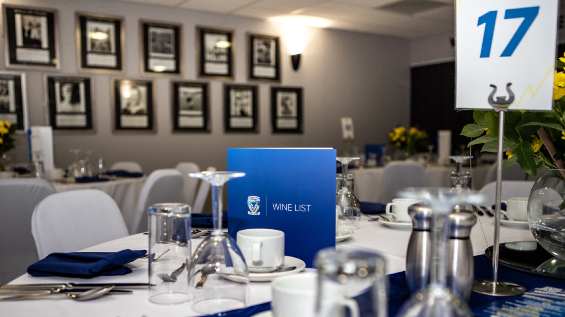 Hall of Fame Lounge gala dinner setup with formal table linens at Halliwell Jones Stadium.