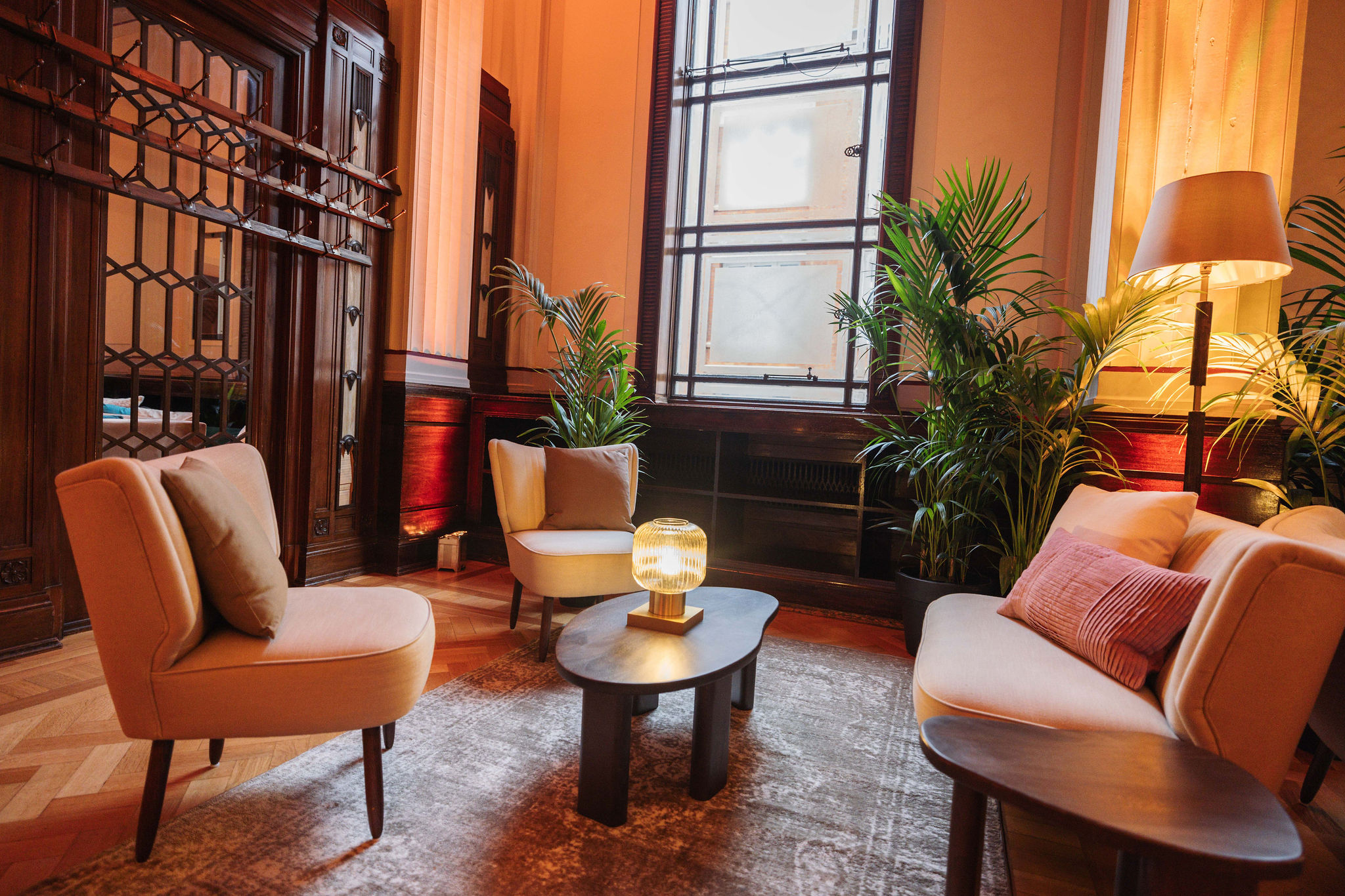 Inviting lounge in The Long Room, ideal for networking events with plush seating and greenery.