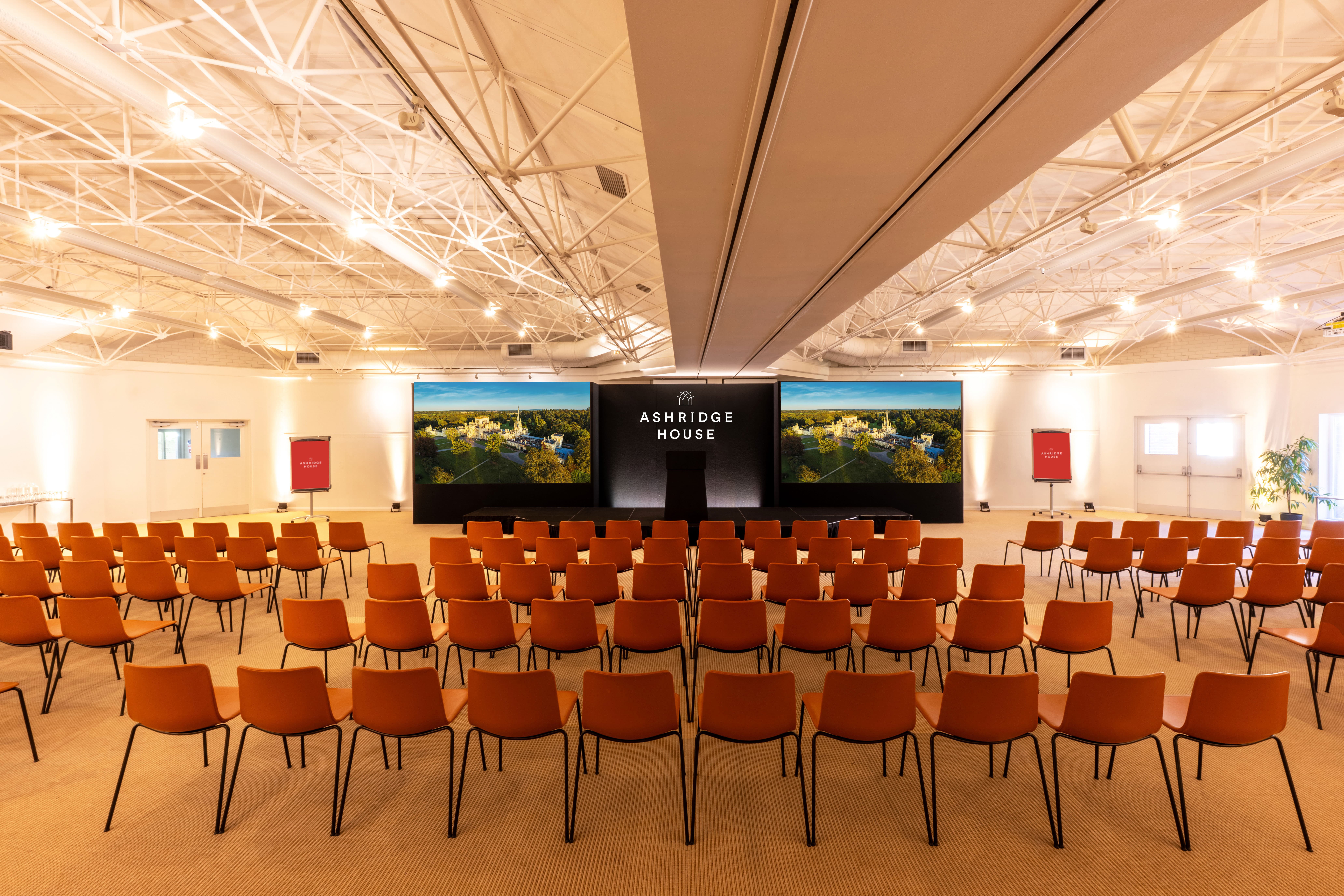 Fairhaven event space at Ashridge House with theater seating and LED screen for corporate conferences.