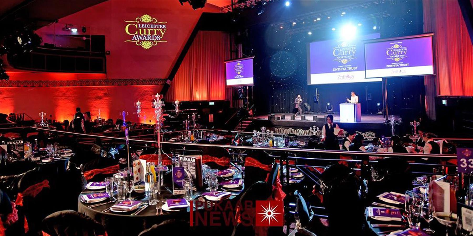 Elegant banquet hall in Athena for awards ceremony with ambient lighting and stage setup.