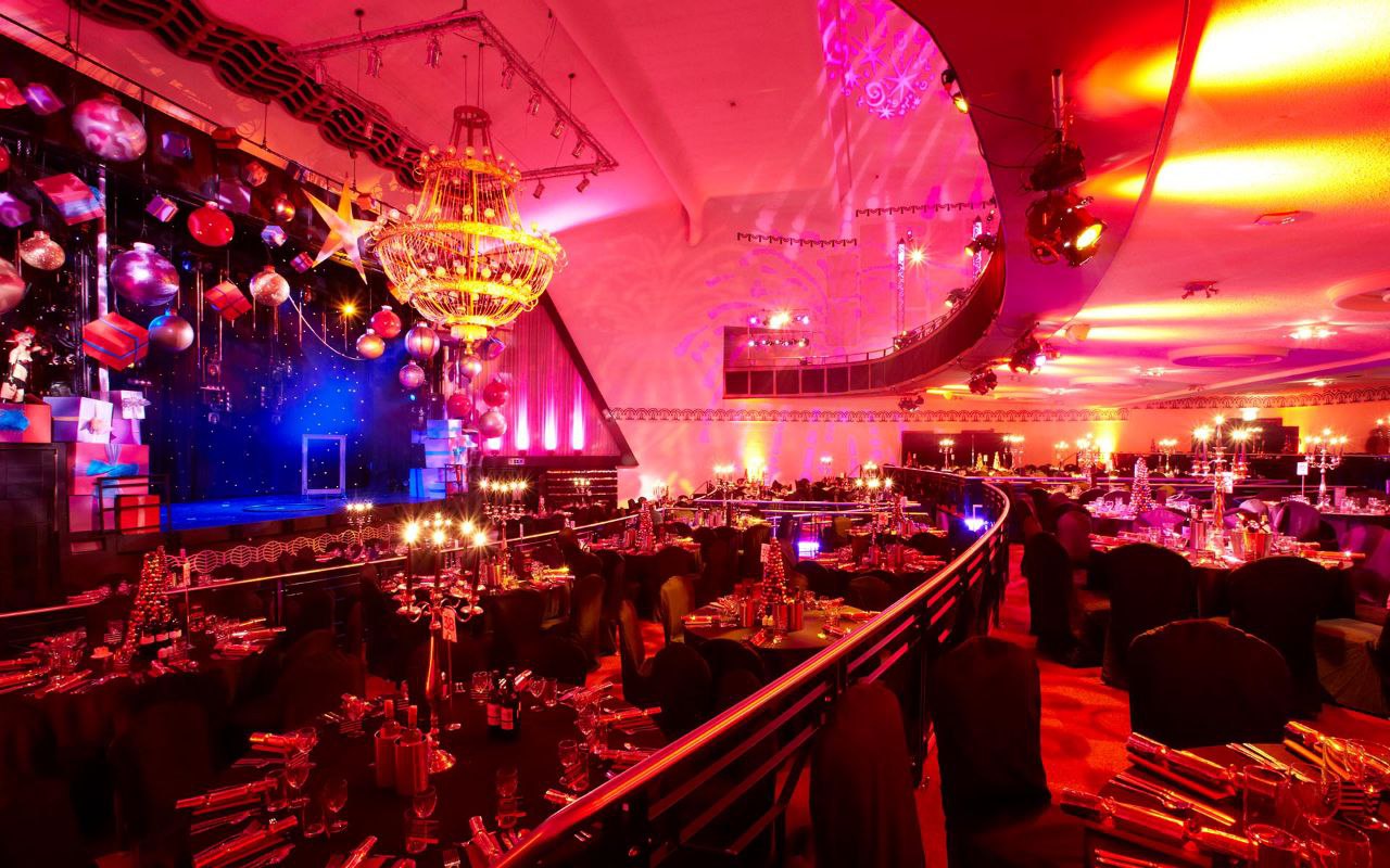 Elegant gala venue in Athena with vibrant lighting and sophisticated chandelier.