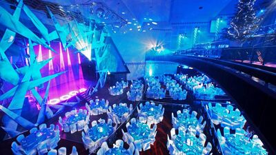 Elegant event space in Athena with round tables and soft blue lighting for formal gatherings.