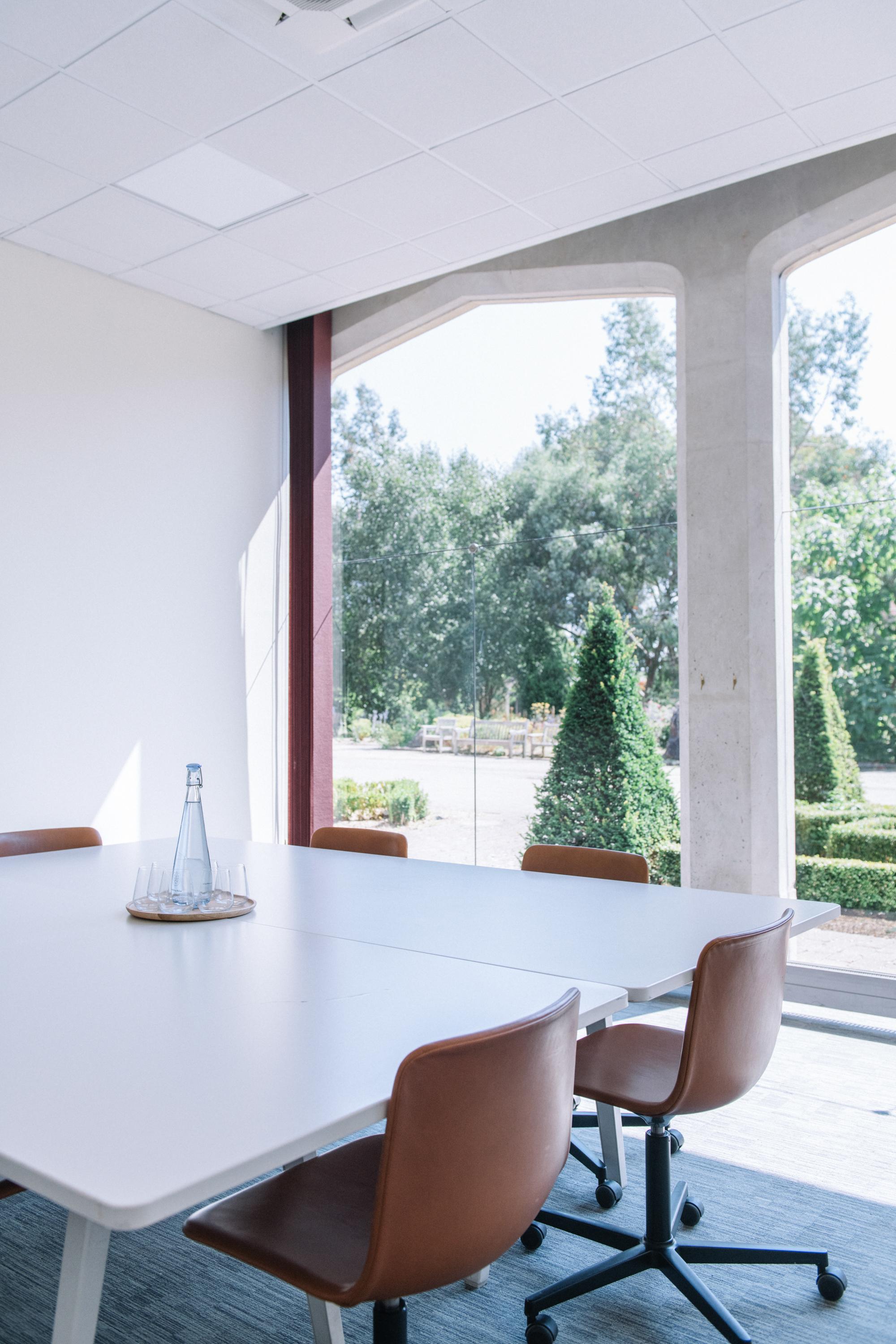 Modern meeting space in Ashridge House with large white table and natural light.