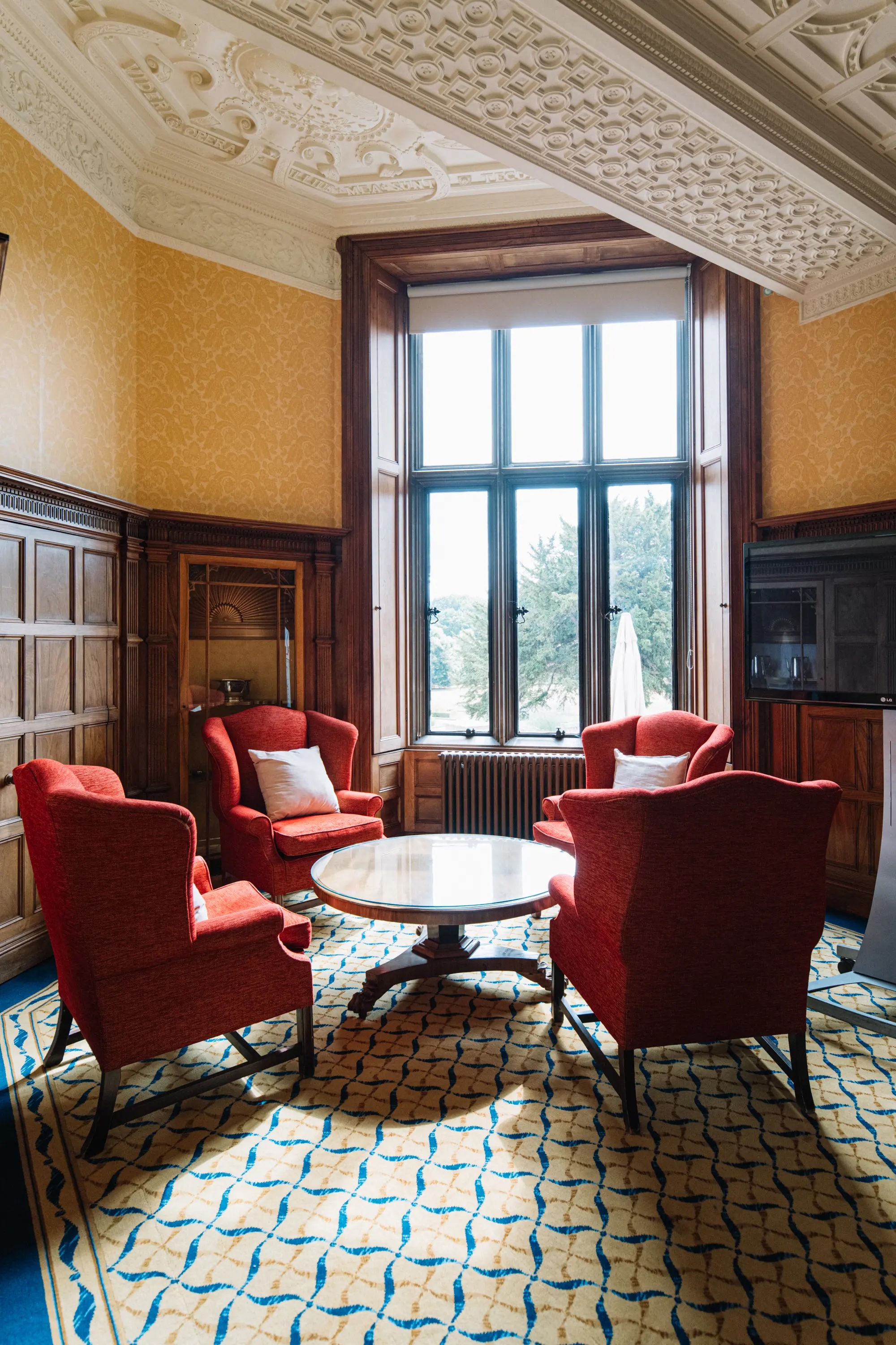 Cozy meeting space in Ashridge House with red chairs for intimate discussions.