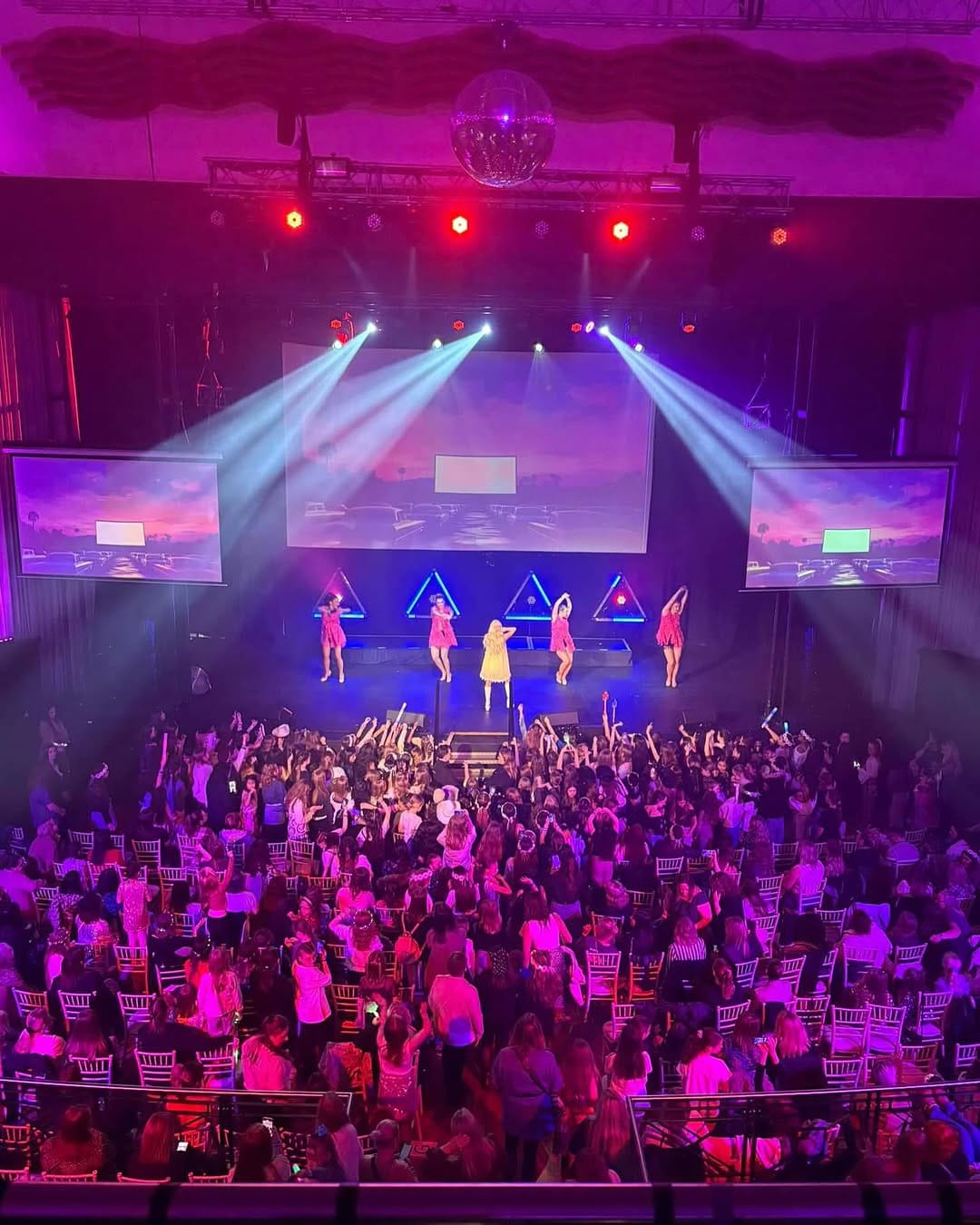 Vibrant stage performance at Whole Venue in Athena with dynamic dancers and engaged audience.