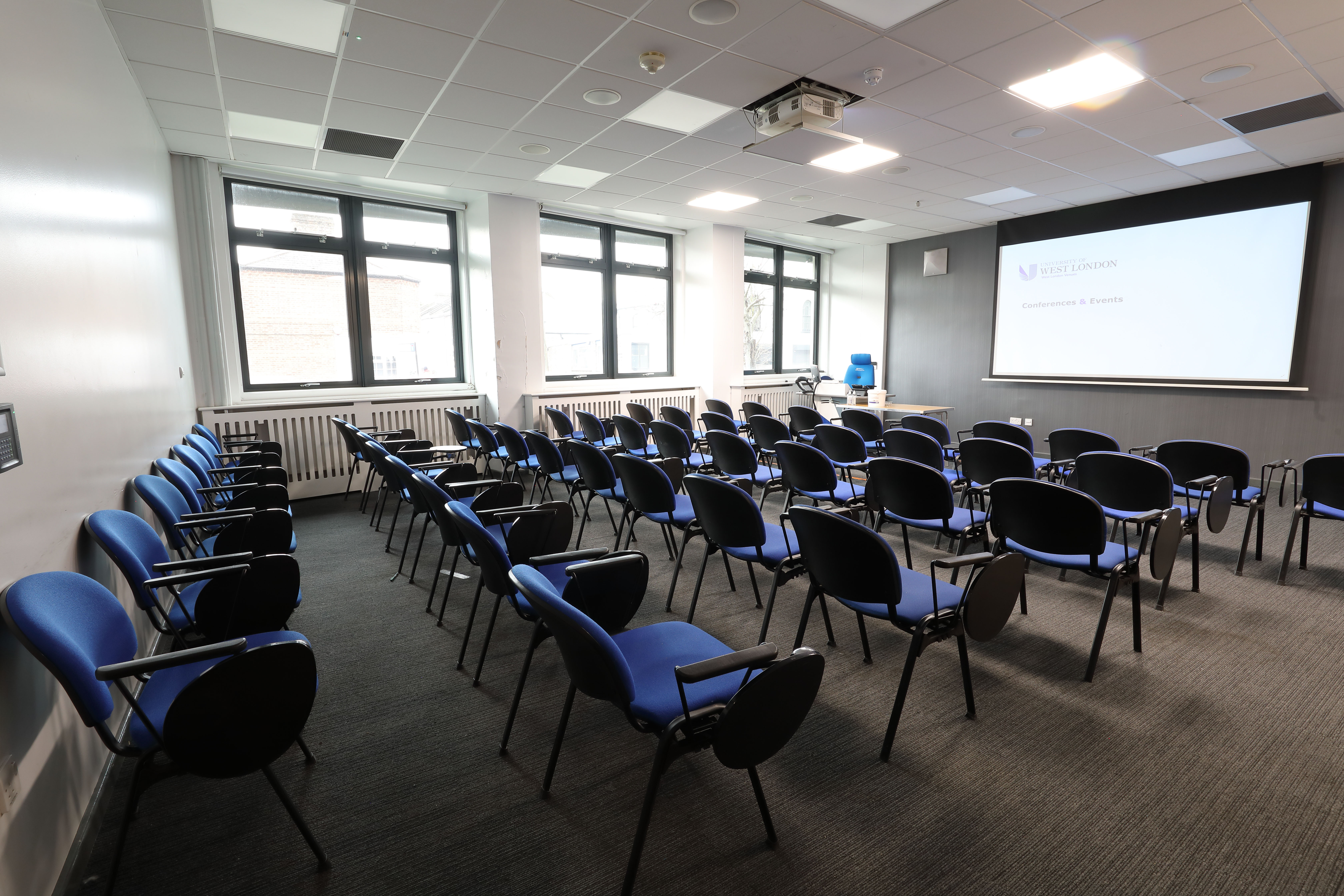Classroom at University of West London with blue chairs for workshops and presentations.