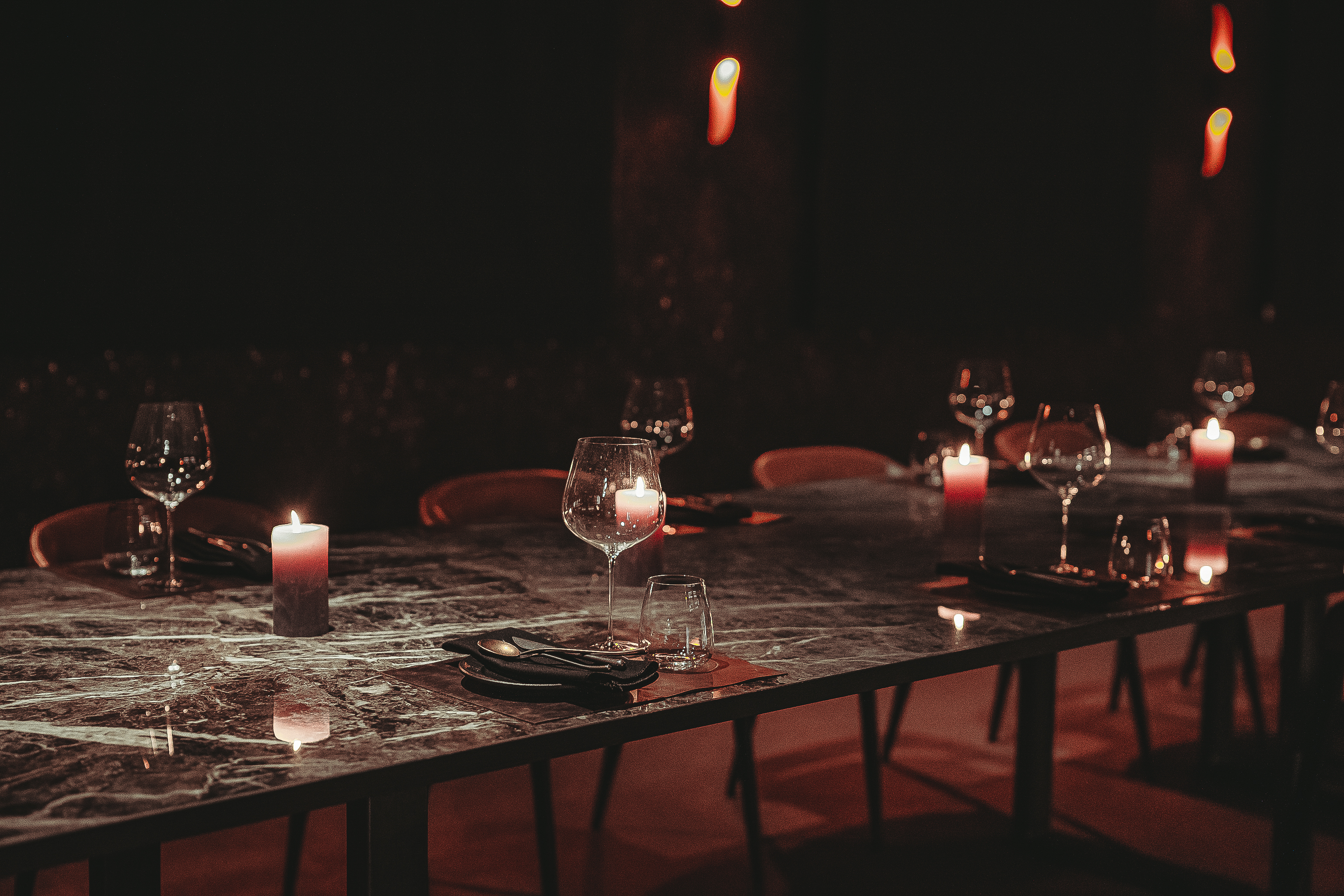 Intimate board dinner setup with elegant glassware and marble tables at Etna in Hora.