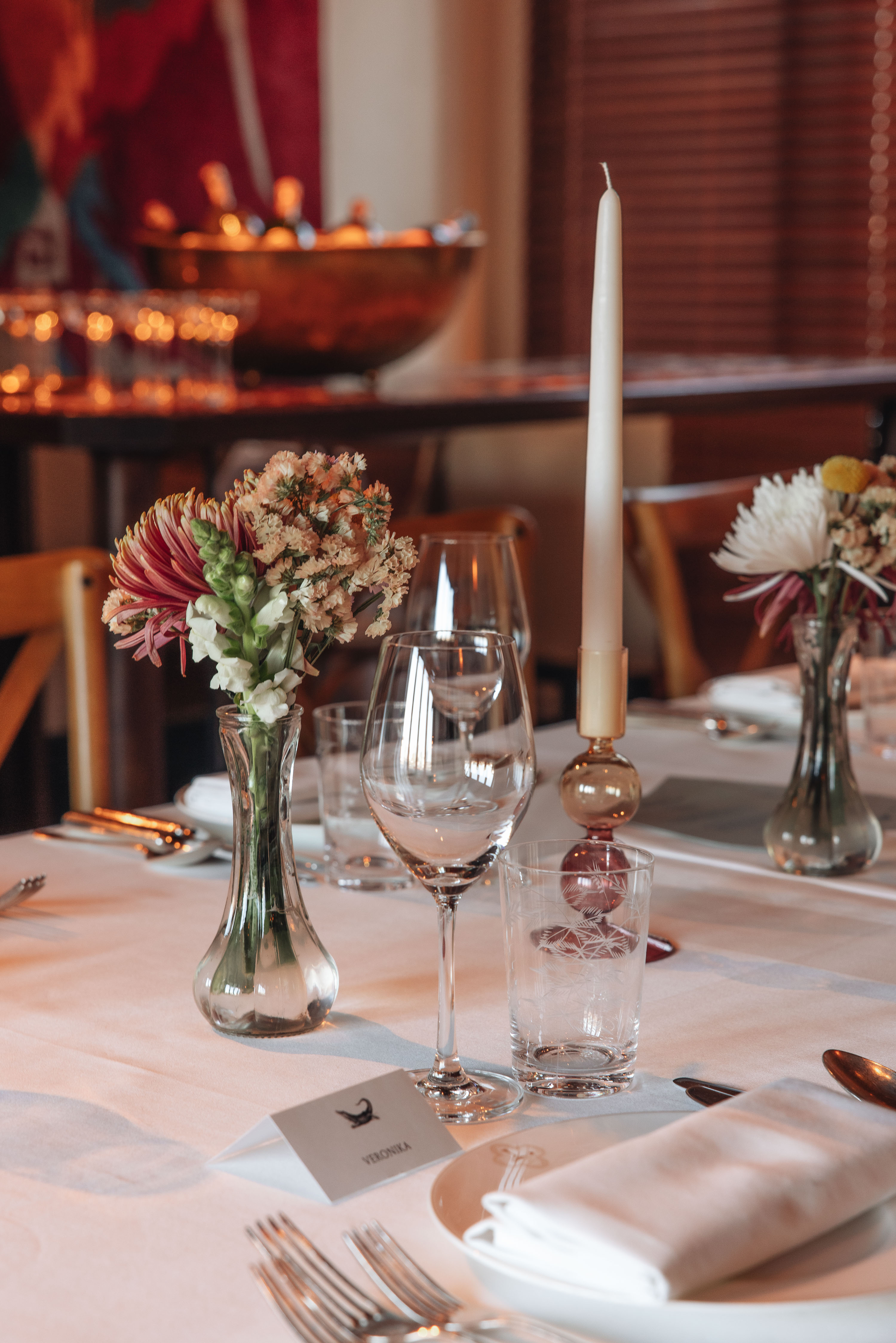 Elegant table setting with floral arrangements for a refined dining event.