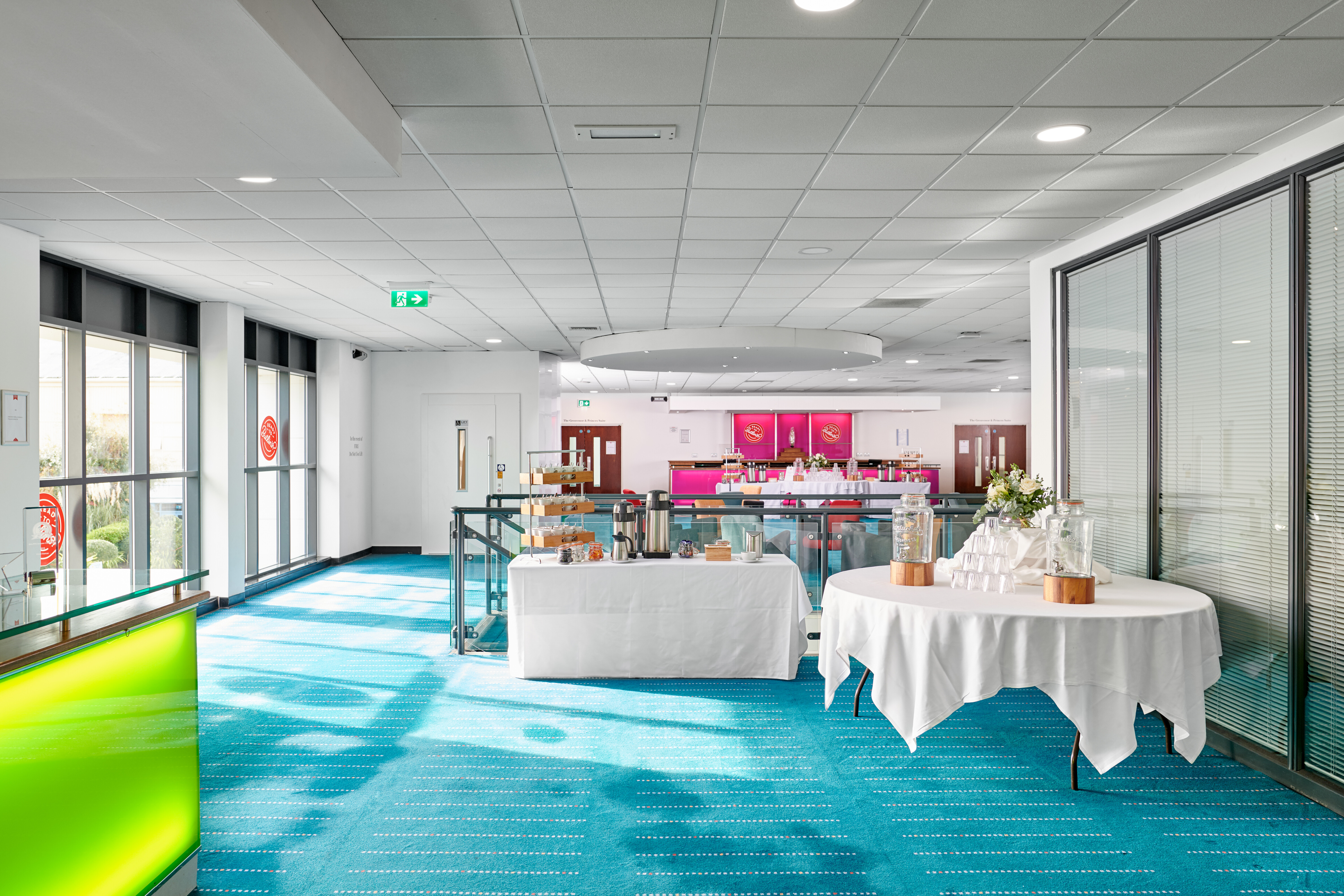 Modern conference centre in Butlin's Bognor Regis with vibrant blue carpeting; ideal for meetings.