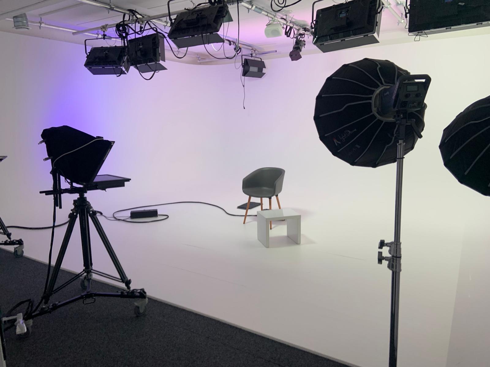 Minimalist digital studio with chair and lighting, ideal for virtual events and interviews.