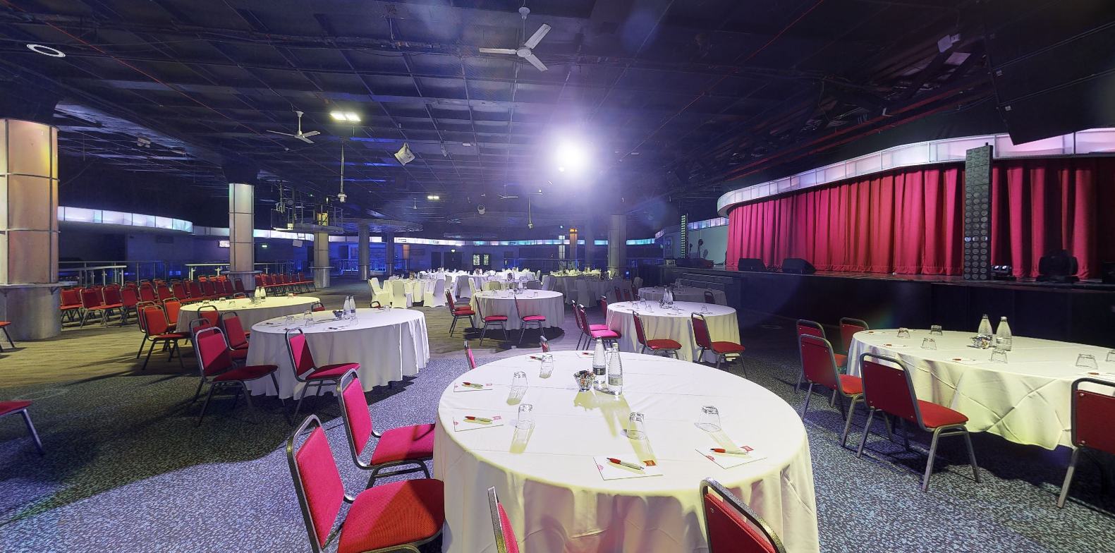 Reds event space at Butlin's Bognor Regis, set for a banquet with round tables and red chairs.