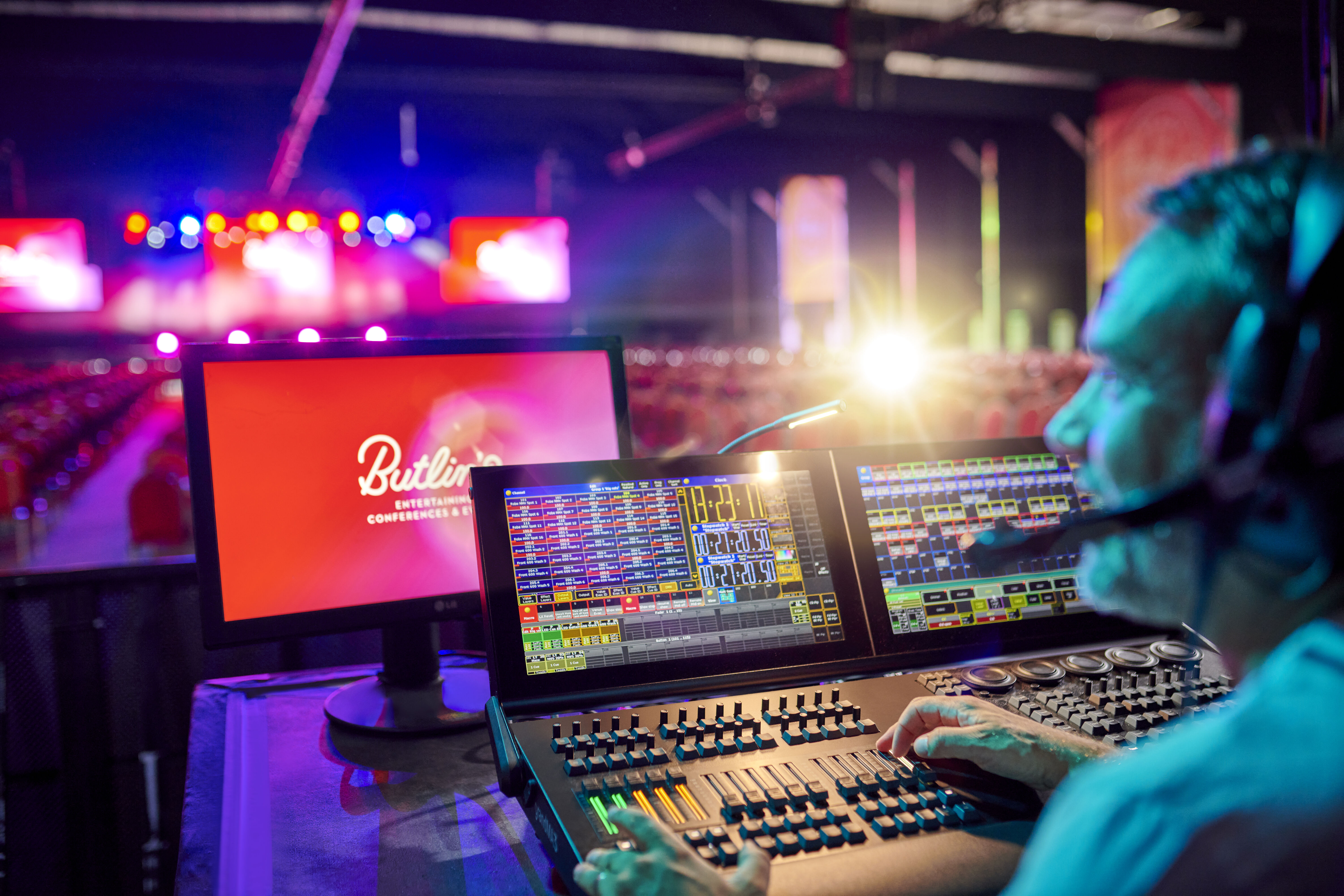 Professional audio-visual operator in control room at Butlin's Bognor Regis event setup.