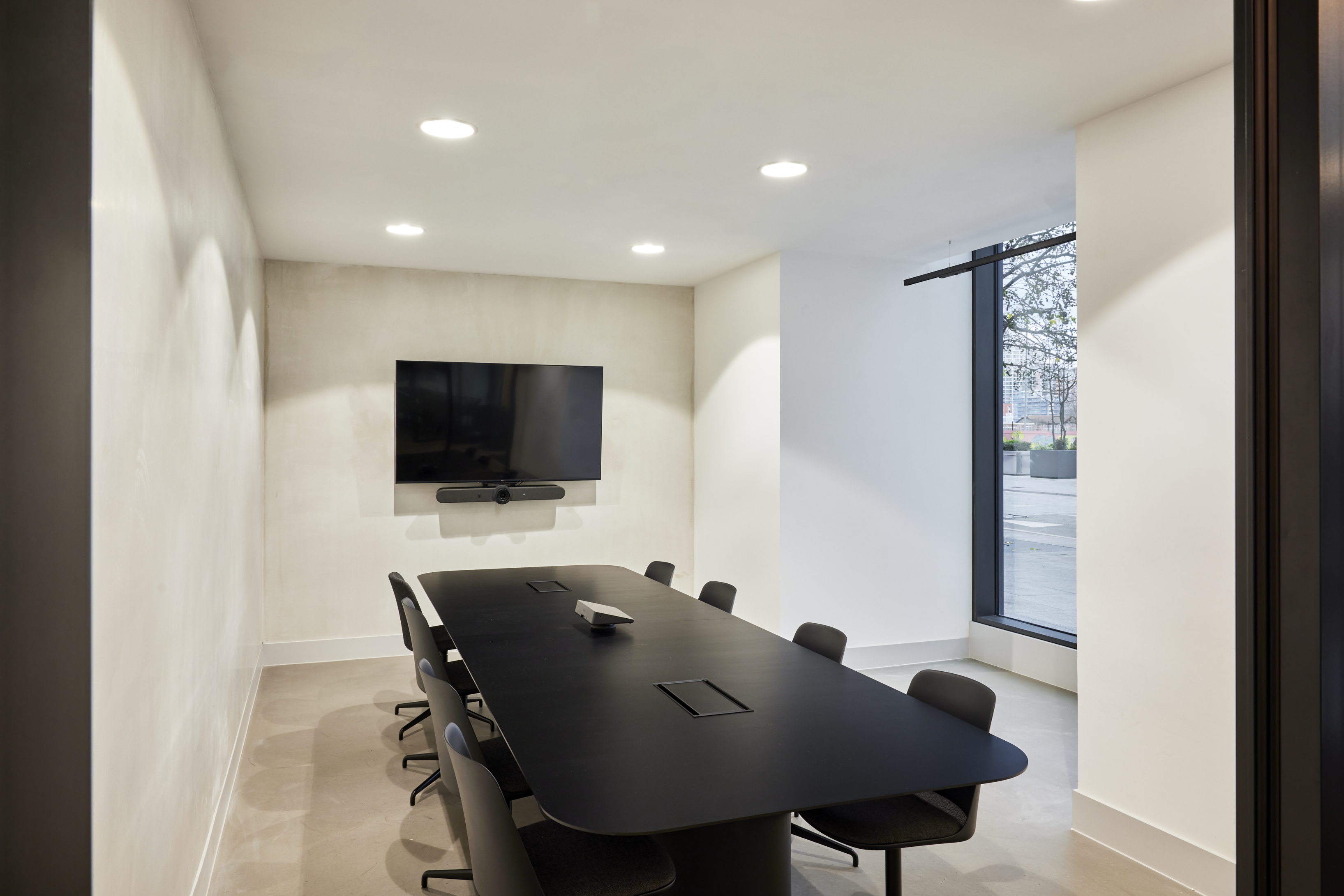 Modern meeting room with black table, ideal for presentations and collaboration.