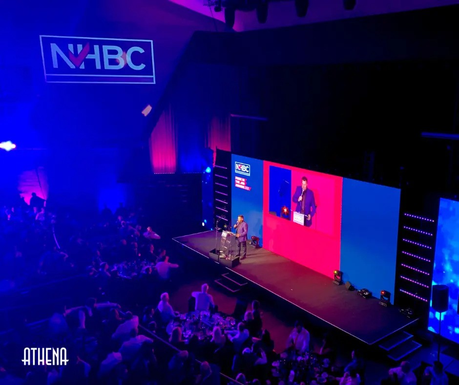 "Dynamic event setup at Athena Space with speaker and vibrant lighting for networking."