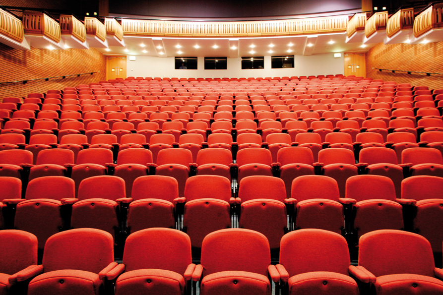 Millennium Theatre auditorium with red seats, perfect for conferences and performances.