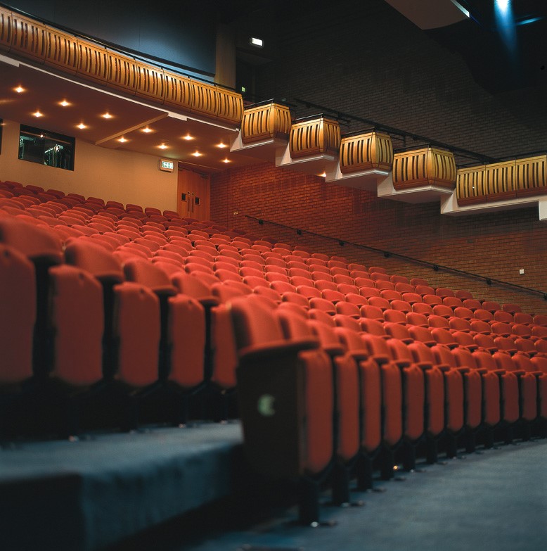 Millennium Theatre auditorium with red seating, ideal for conferences and performances.