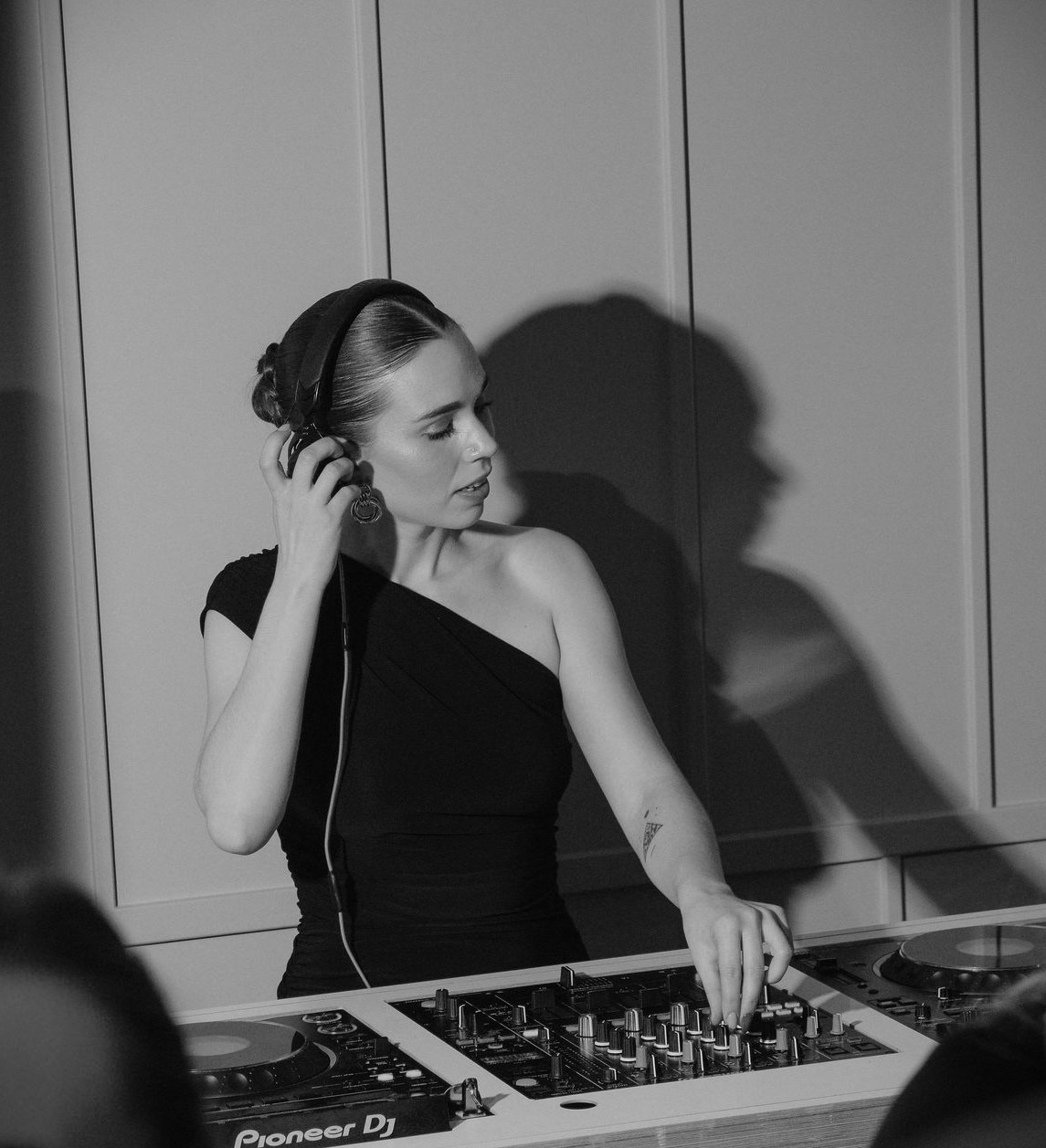 DJ at JOIA Rooftop, stylish headphones, upscale event in London Battersea.