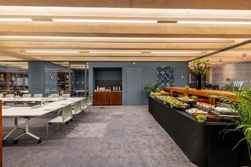 Modern library meeting room with buffet setup, perfect for networking events and workshops.