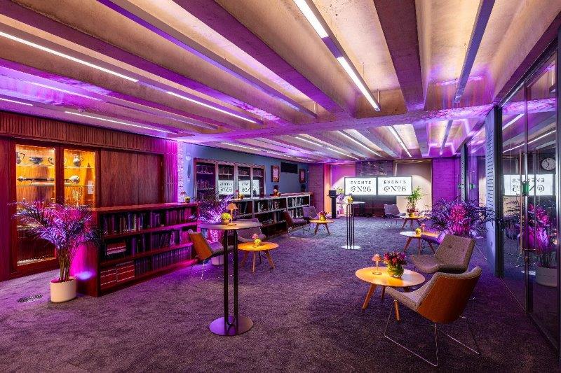 Modern library meeting room with purple lighting for versatile events and networking.