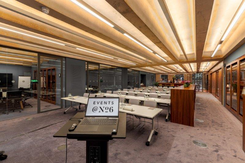 Modern library meeting room with tables, ideal for events and presentations.