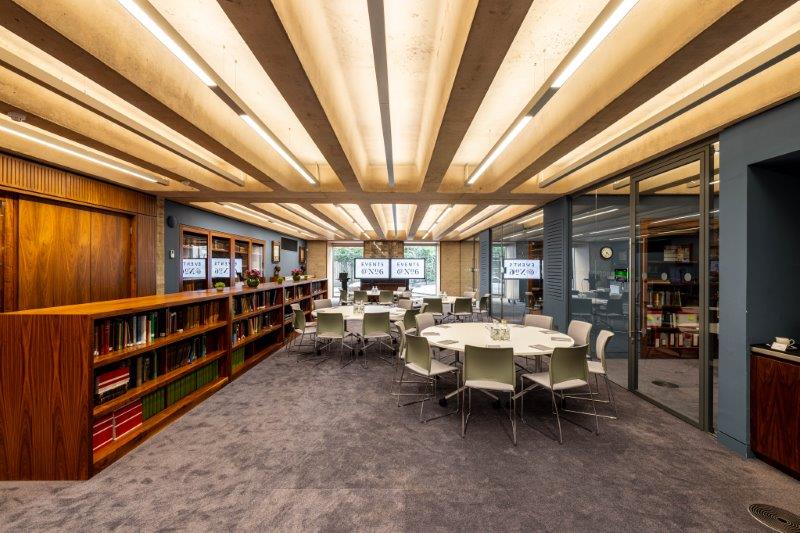 Modern library meeting room with circular tables, ideal for events and collaboration.