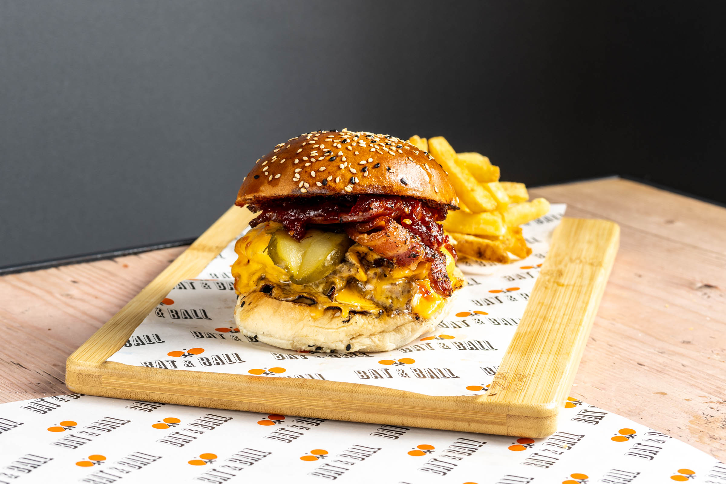 Gourmet burger with melted cheese and fries at Players Lounge, ideal for events and gatherings.