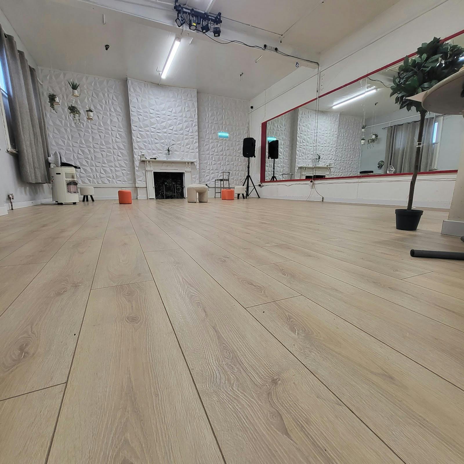 Sovereign Studios blank-canvas space with wood floors for intimate workshops and wellness events.