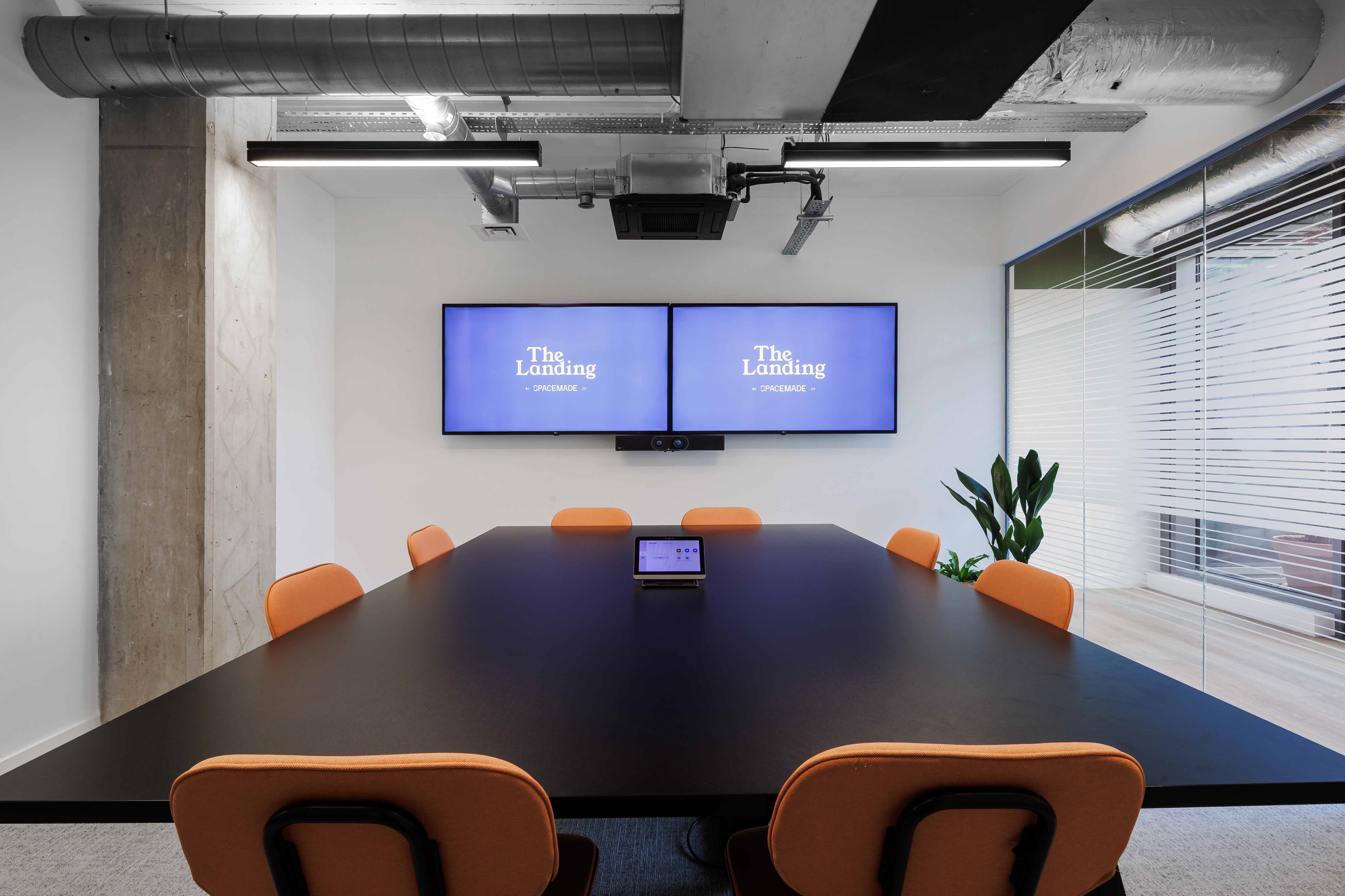 Modern Ackerley Meeting Room with sleek black table, ideal for corporate meetings and events.