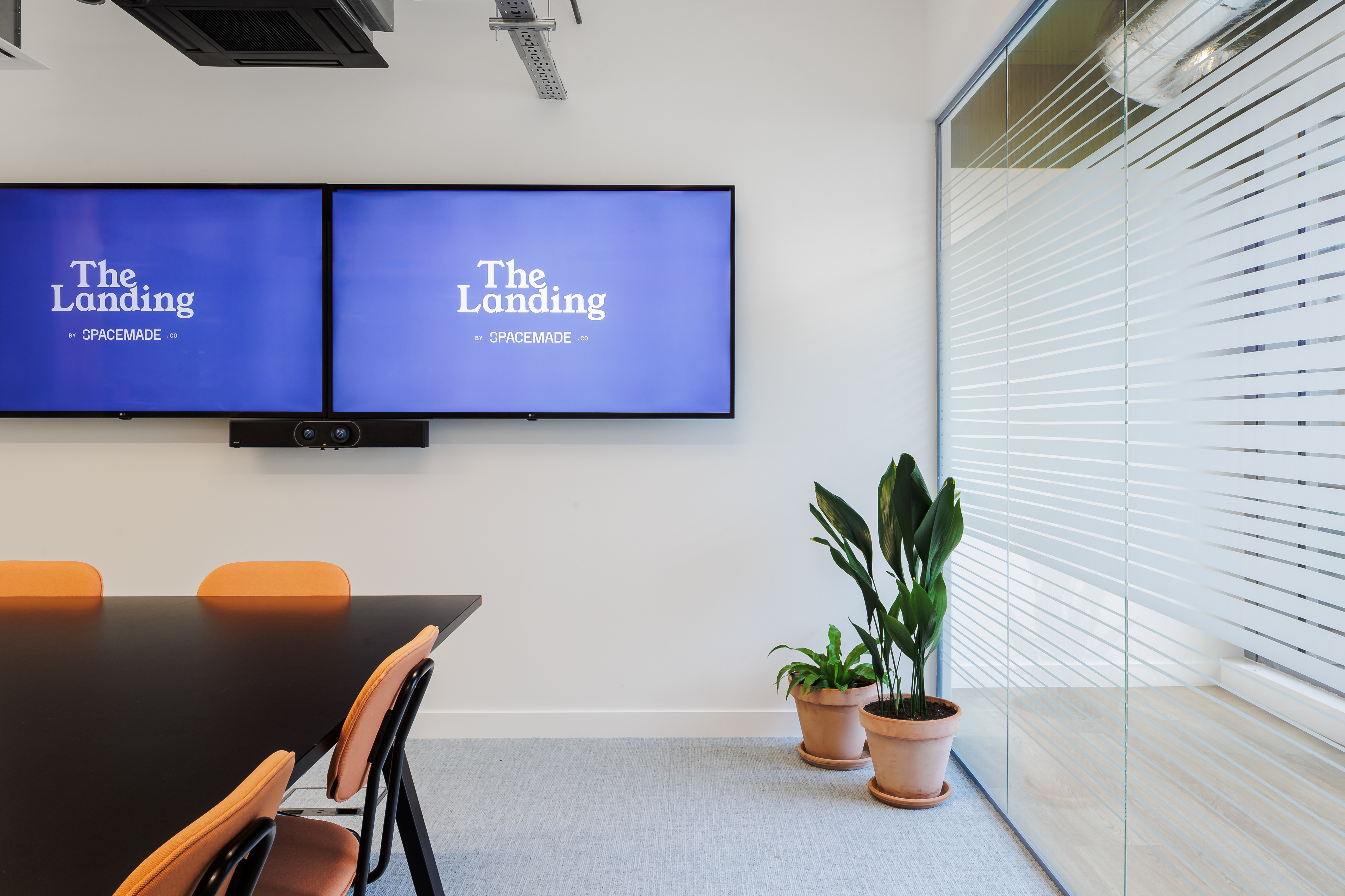 Modern Ackerley Meeting Room with dual screens for presentations and collaboration.