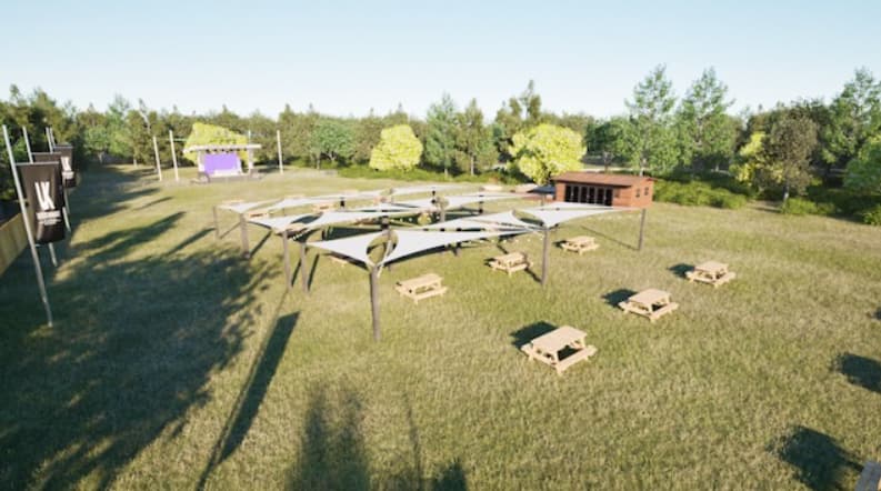 Outdoor corporate retreat venue with stage and seating for team-building festivals.
