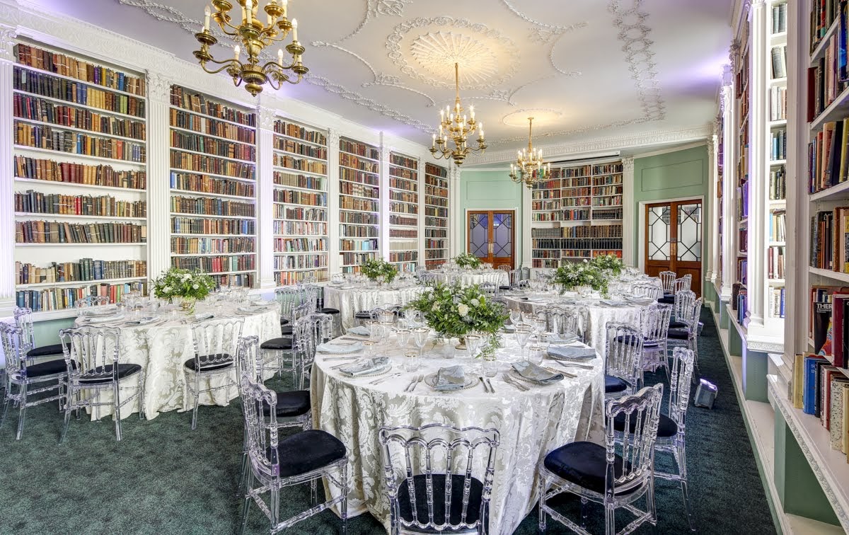 Elegant library venue with round tables, ideal for formal gatherings and receptions.
