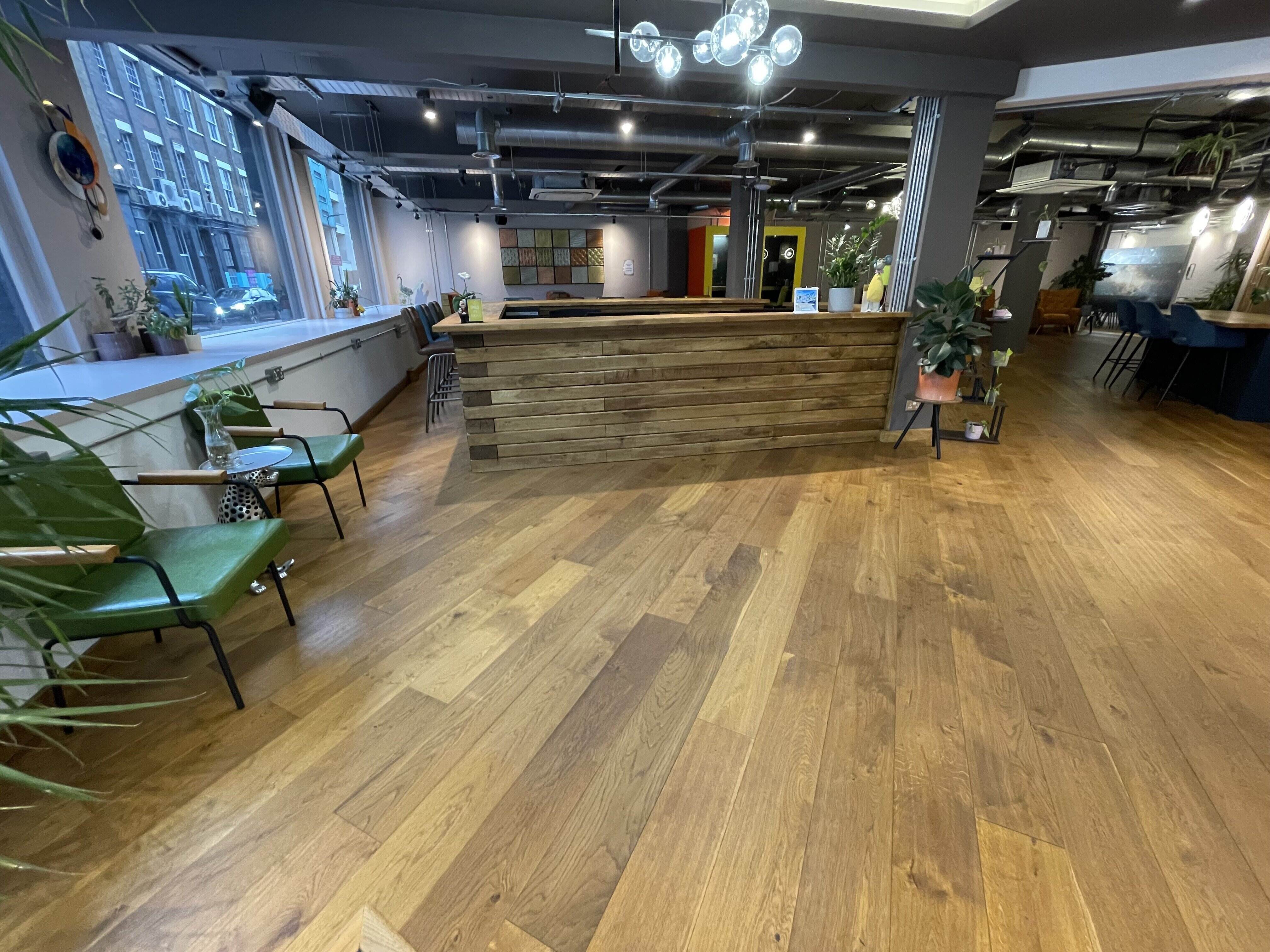 Industrial breakout space at The Lower Deck with wooden bar for networking and event registration.