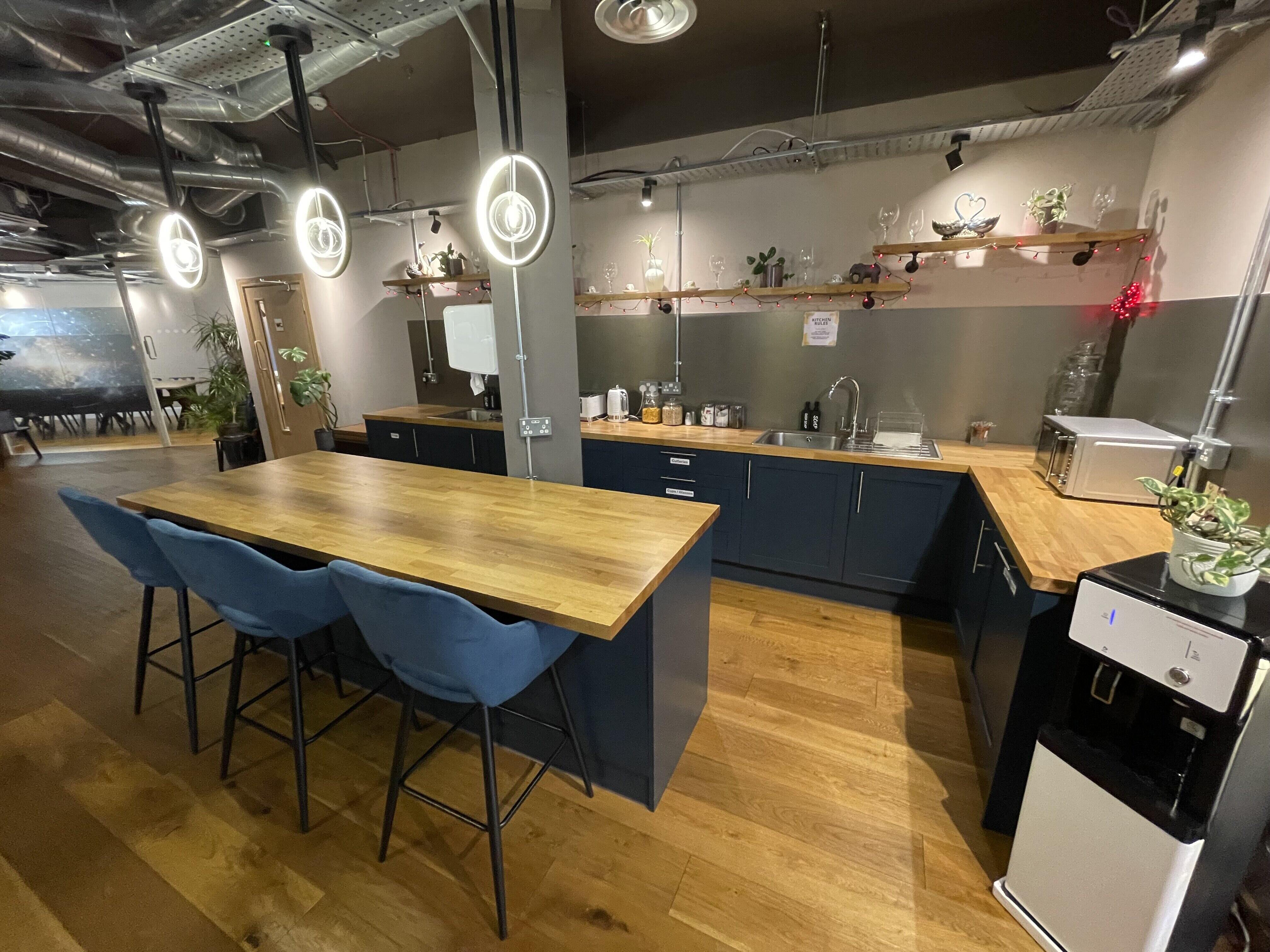 Industrial breakout space with kitchenette for creative workshops and corporate team sessions.