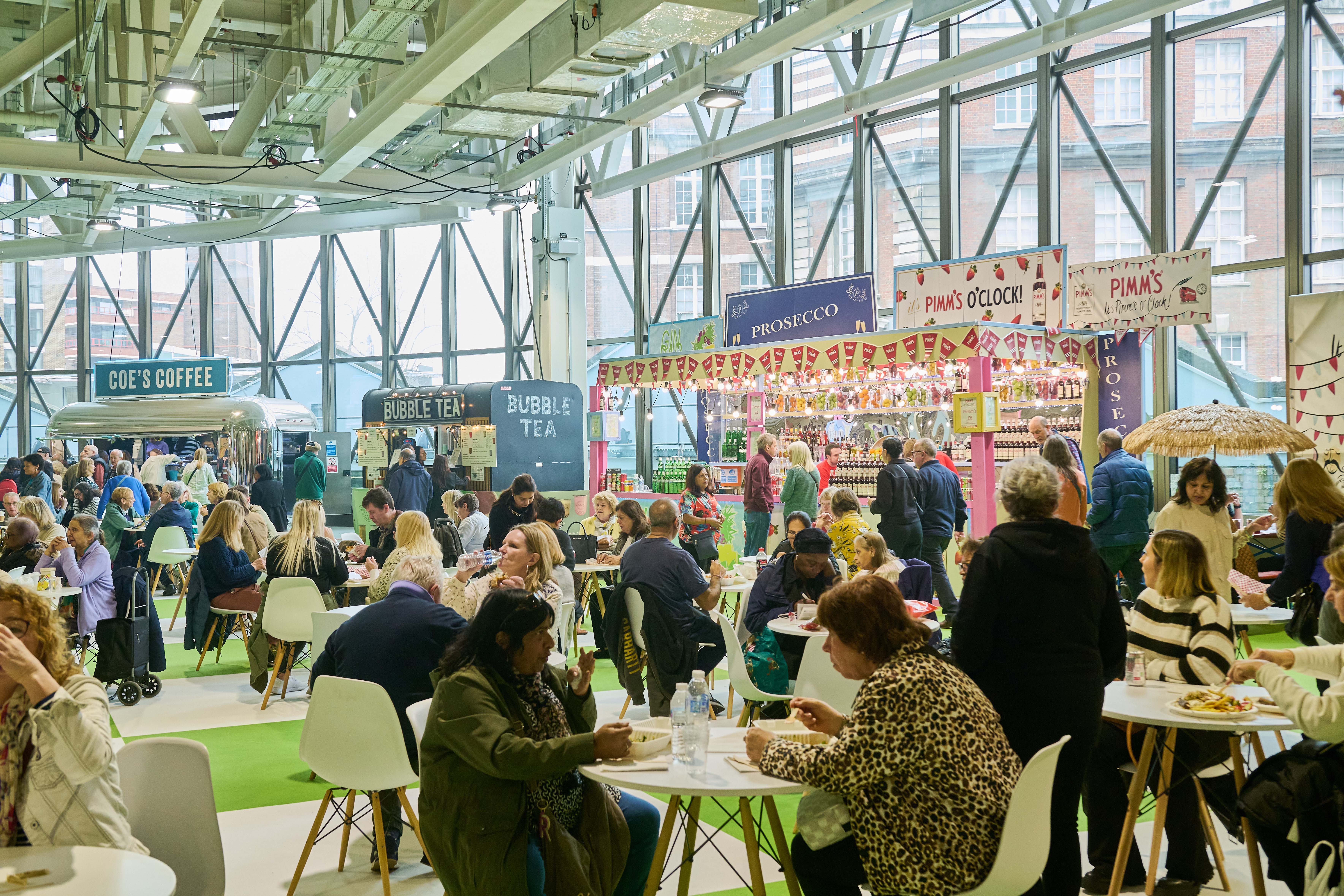 Vibrant West Hall event space with attendees enjoying food and drinks, ideal for networking.