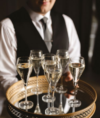 Polished waiter serving sparkling wine at an elegant Christmas party in Chester.