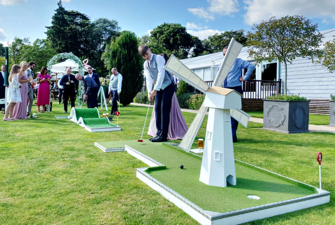 Summer party in Chester with guests enjoying miniature golf on a green lawn.