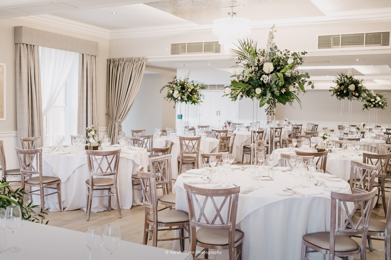 Elegant wedding venue at Old Palace Chester with round tables and floral centerpieces.