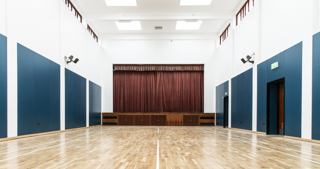 Spacious Sports Hall with polished wooden floor, ideal for corporate events and gatherings.