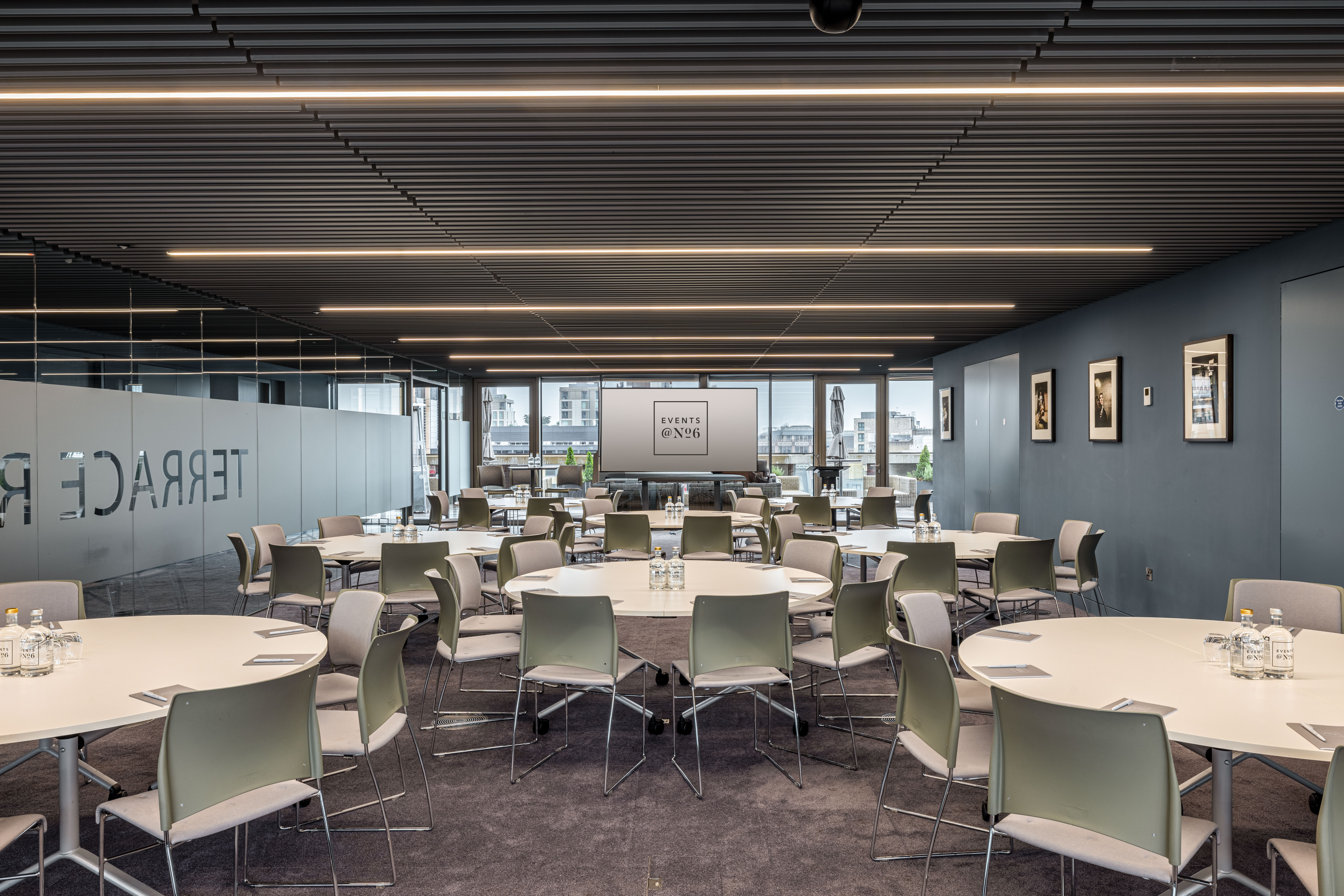 Modern rooftop event space with round tables for summer parties and networking.