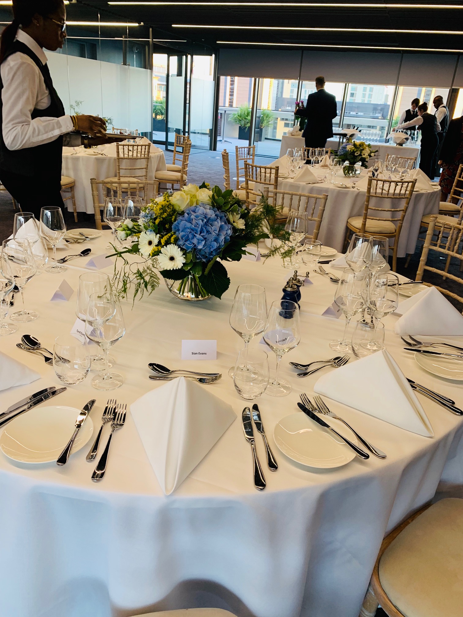 Elegant rooftop dining table with fresh flowers for summer weddings and events.