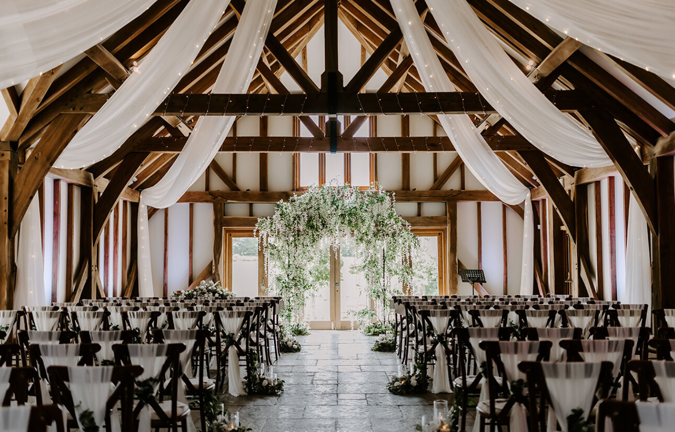 Elegant wedding ceremony at Brookfield Barn with floral arch and rustic charm.