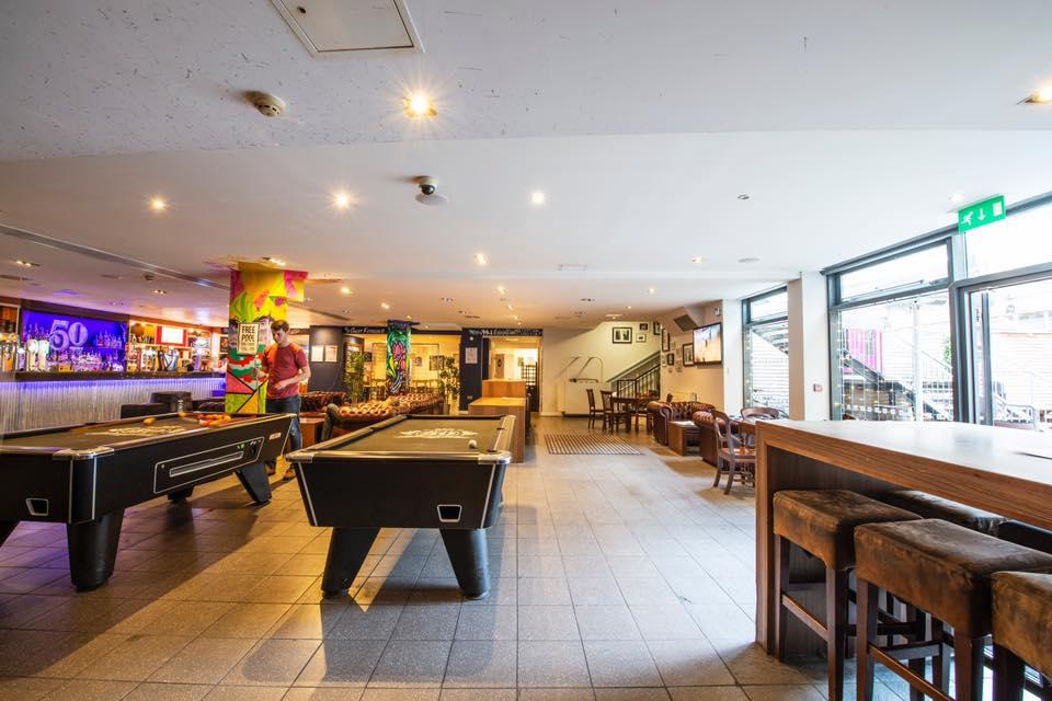 Pool hall at Bar 50 with pool tables, ideal for networking and social events.
