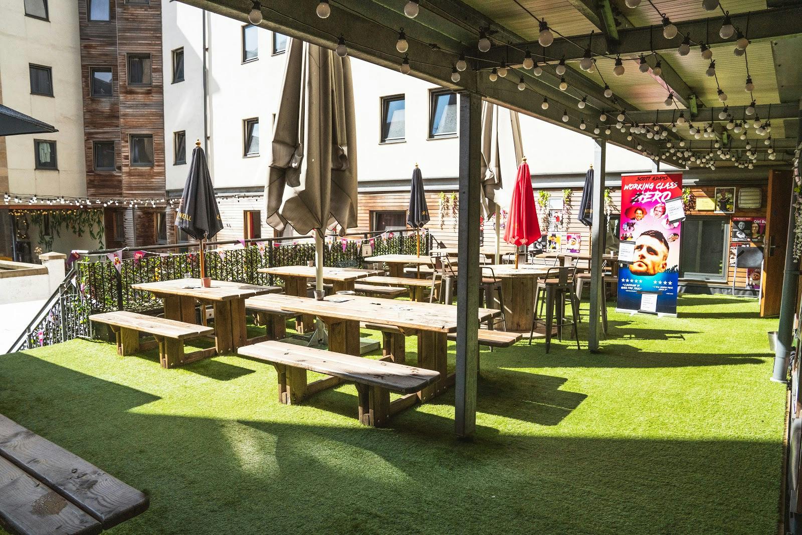 Covered outdoor function room with bench seating for networking and team-building events.