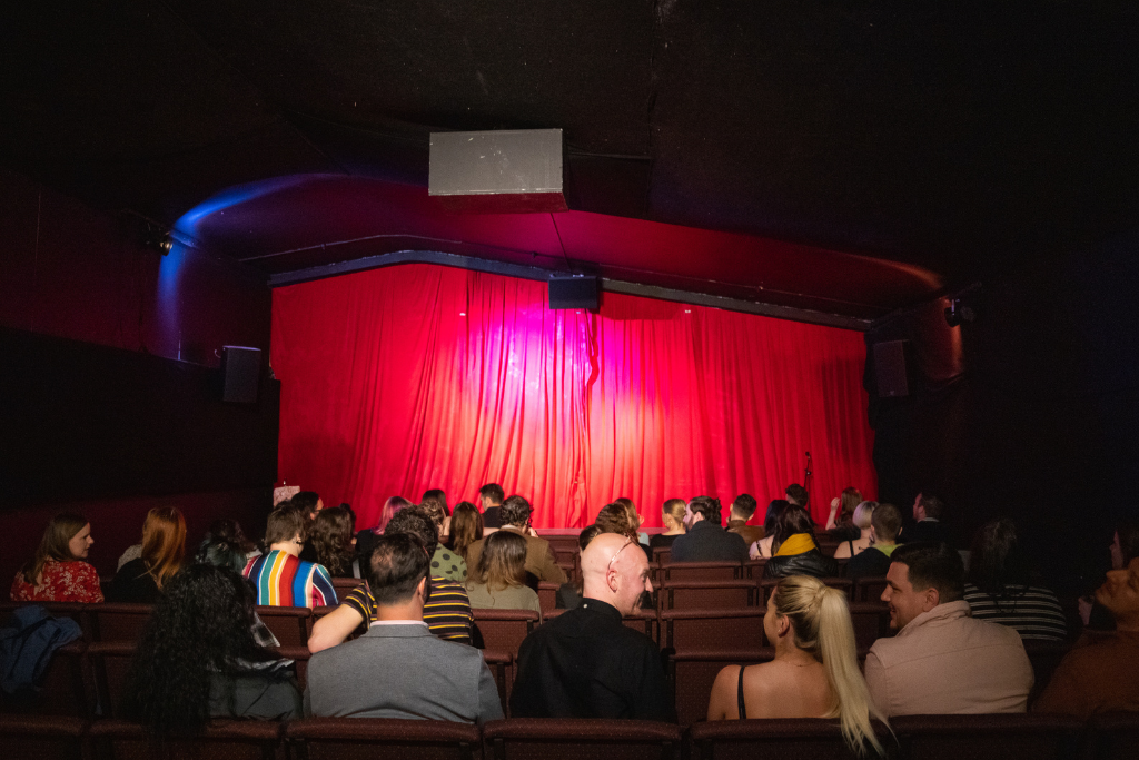 Cozy performance venue with red curtains, ideal for events and networking at GRUB MCR.